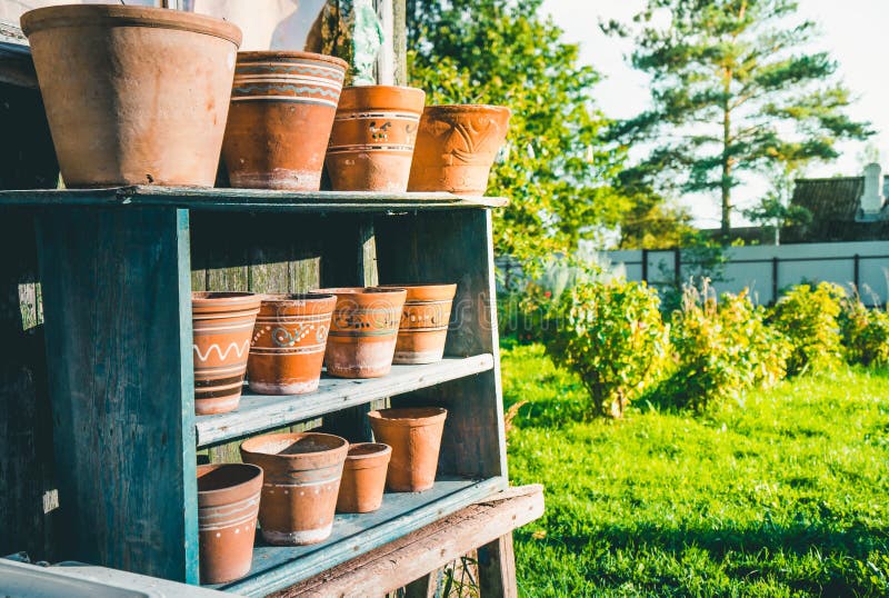 Vintage clay pots with ornamental pattern standing in rows on shelves