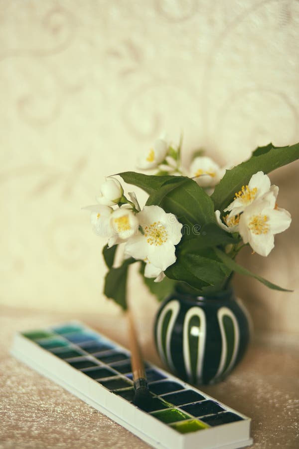 Vintage retro photo of jasmine flowers in little vase with a watercolor box and a brush stock photos Vintage retro photo of jasmine flowers in little vase with a watercolor box and a brush stock photos