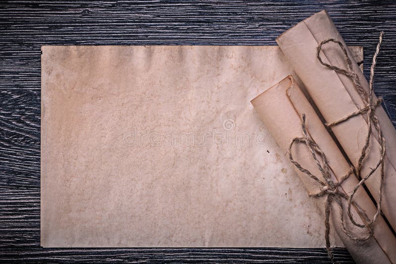 Vintage rolled medieval paper on wooden background stock photos