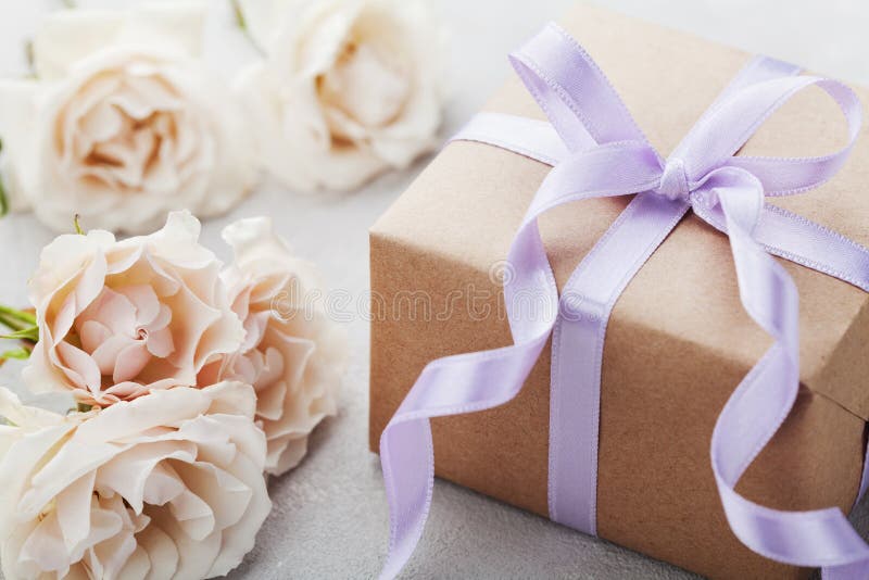 Vintage rose flowers and gift box with ribbon on light table. Greeting card for Birthday, Womens or Mothers Day. Vintage rose flowers and gift box on light royalty free stock photography Vintage rose flowers and gift box with ribbon on light table. Greeting card for Birthday, Womens or Mothers Day. Vintage rose flowers and gift box on light royalty free stock photography