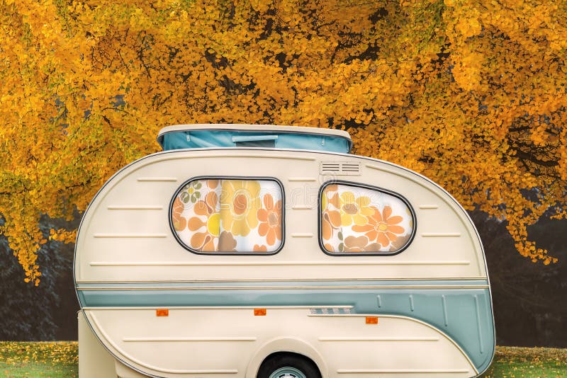 Vintage seventies white caravan with flower curtains in front of stock image