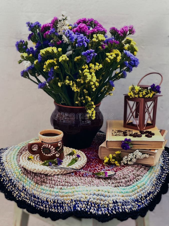 Vintage still life with dried flowers, books and a cup on a white background.