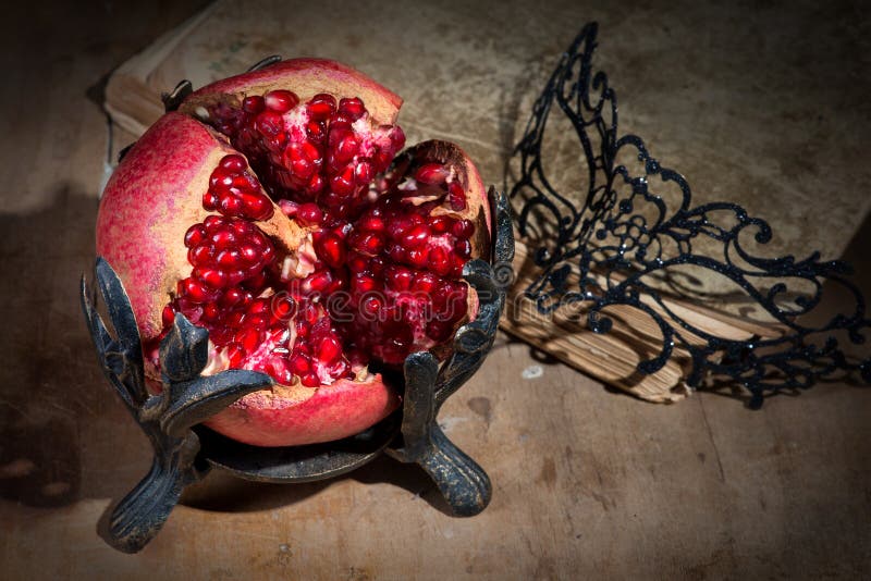 Vintage still life with pomegranate and mask