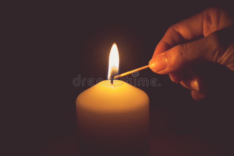 Vintage tone of hand with matchstick, lighting a candle
