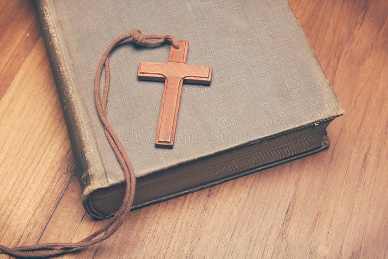 Vintage tone of wooden Christian cross necklace on holy Bible with copy space