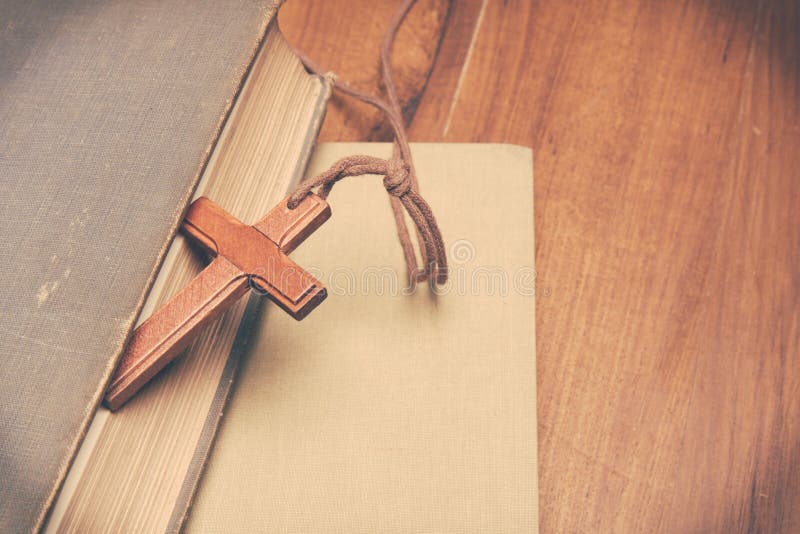 Vintage tone of wooden Christian cross necklace on holy Bible with copy space