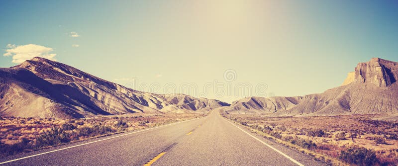 Vintage toned panoramic photo of desert road.