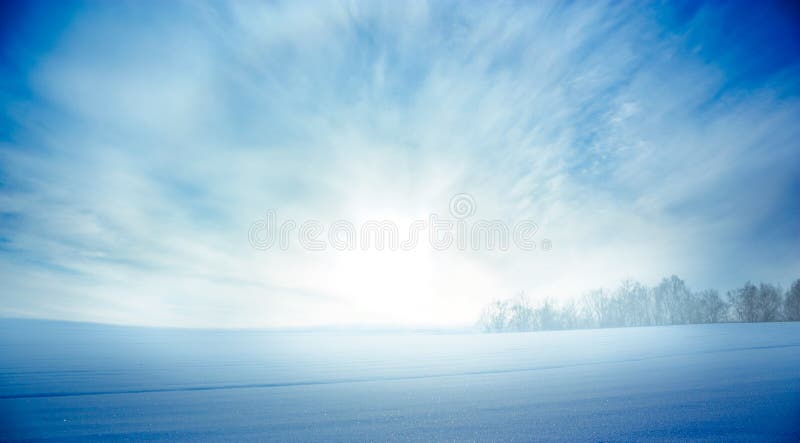 Vinterlandskap med den snöig fält- och resningsolen arkivbilder