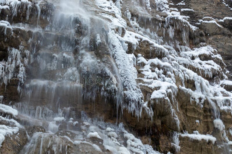 Vinterlandskapet i bergen är vackert, med träd som berövar vattenfall, snö som faller arkivbilder