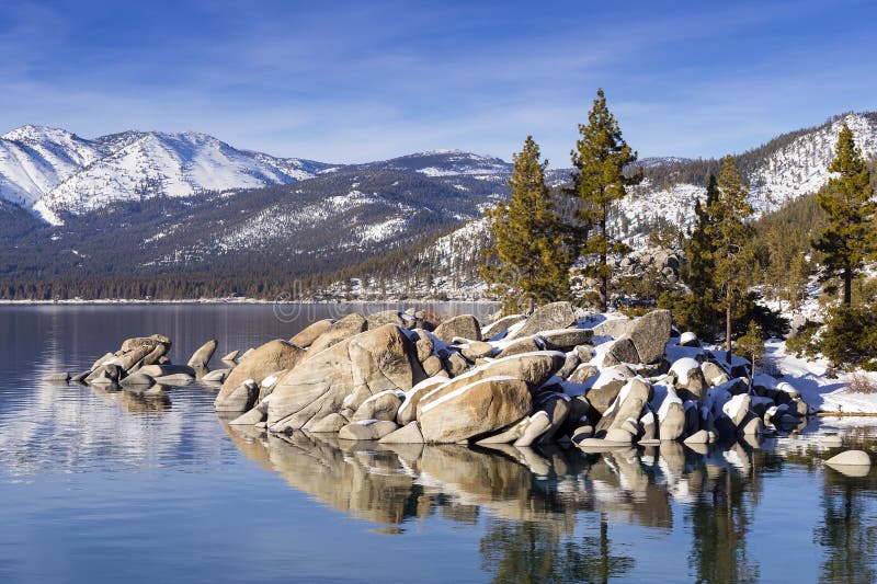 Vinterskottet av Lake Tahoe med snö vaggar på och berg arkivbild Vinterskottet av Lake Tahoe med snö vaggar på och berg arkivbild