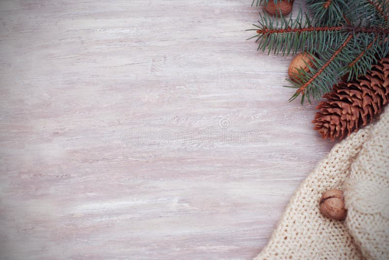 VintersäsongCristmas ram med granfilialer, Pinecones och den stack tröjan på träbakgrunden arkivbilder VintersäsongCristmas ram med granfilialer, Pinecones och den stack tröjan på träbakgrunden arkivbilder
