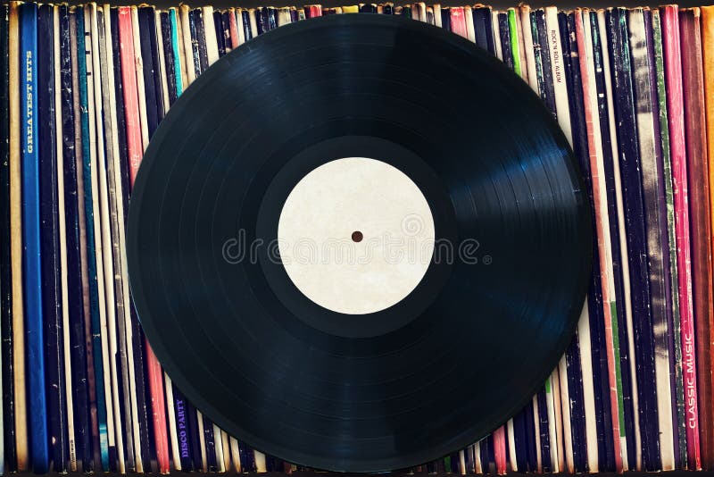 Vinyl record with copy space in front of a collection of albums, vintage process