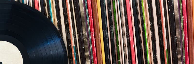 Vinyl record in front of a collection of albums, music concept