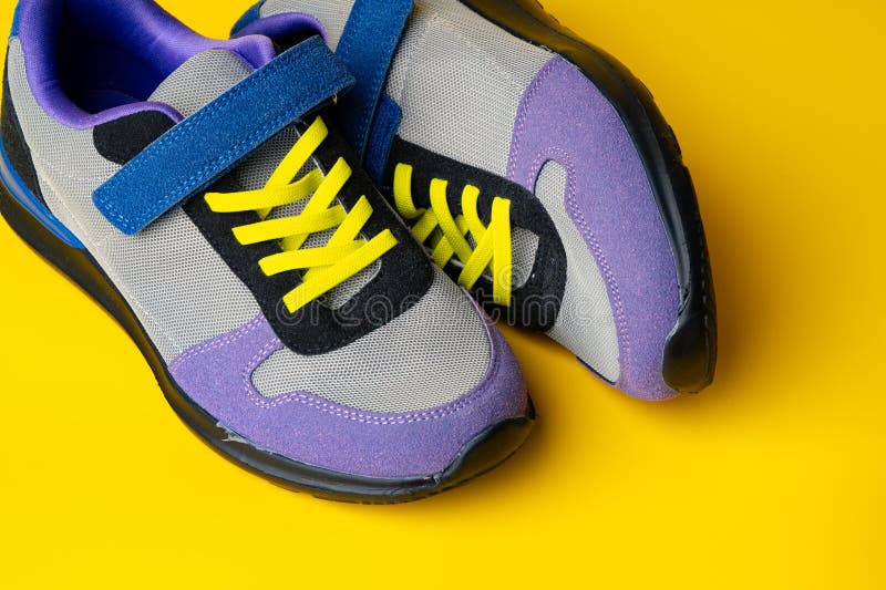 Violetblue Female Sneakers on Yellow Studio Background Stock Photo