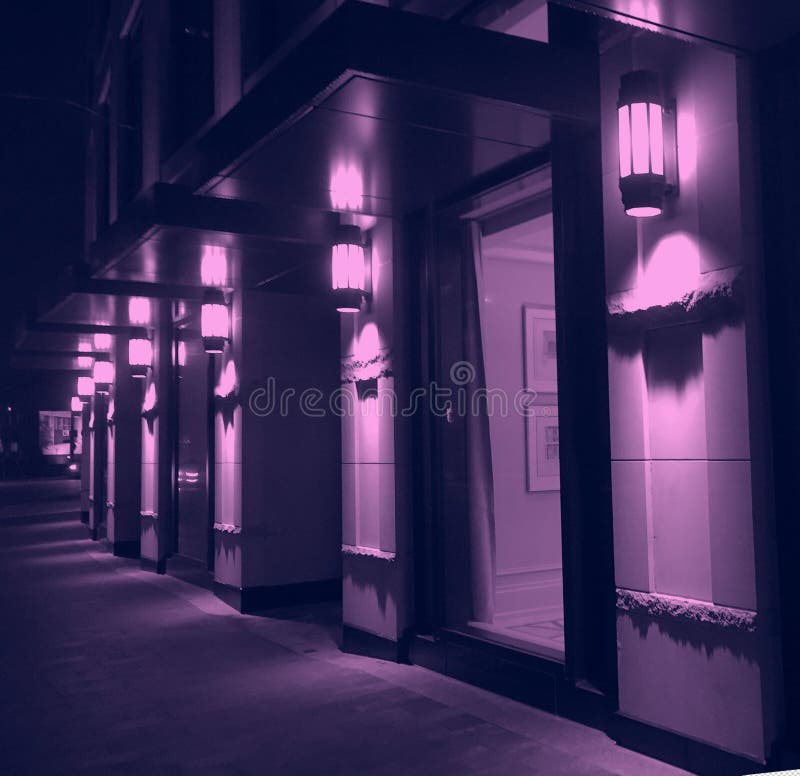 Violet night lighting of modern city building facade