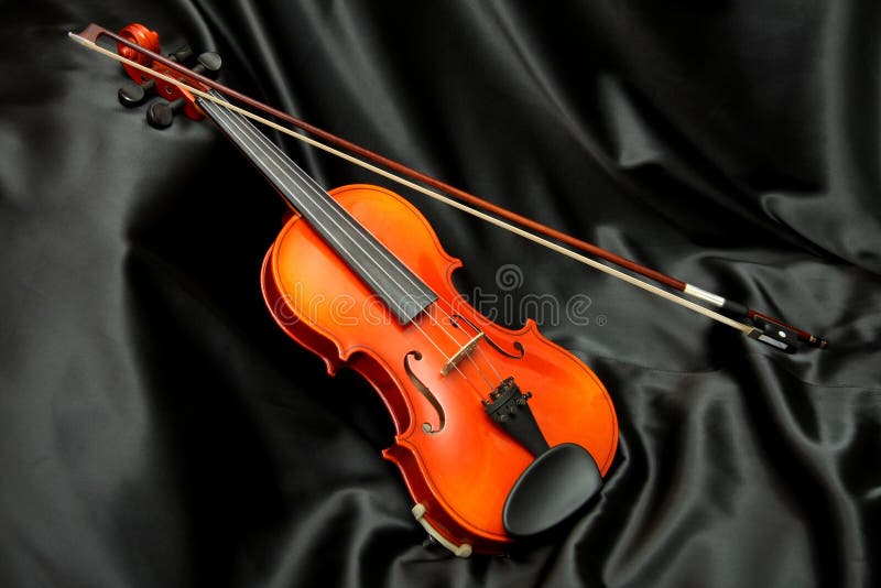 Violin and bow on black silk