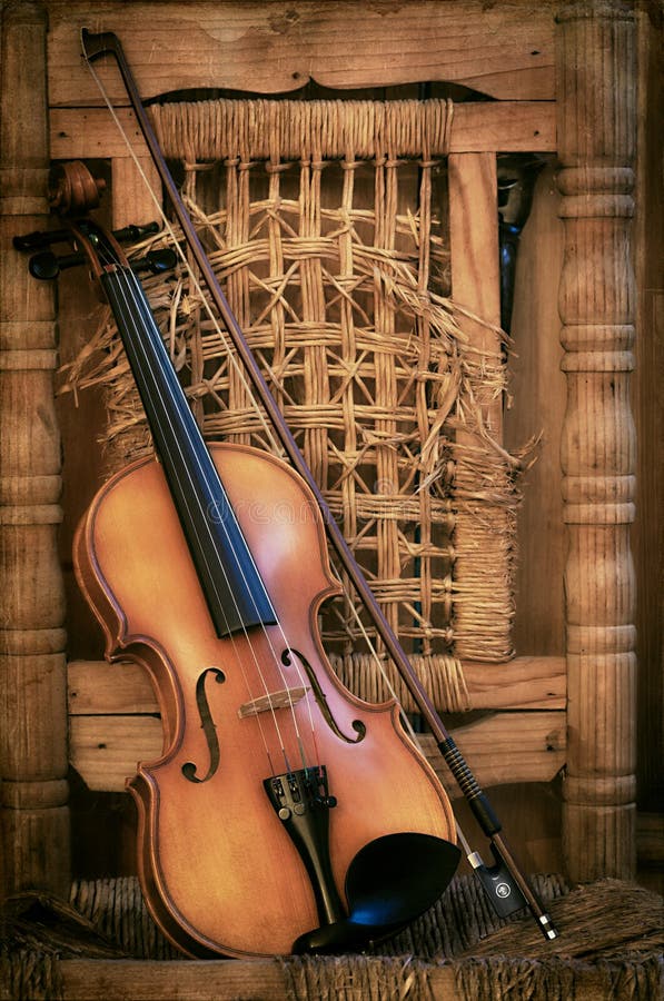Violino velho que encontra-se em uma cadeira arruinada imagem de stock royalty free Violino velho que encontra-se em uma cadeira arruinada imagem de stock royalty free