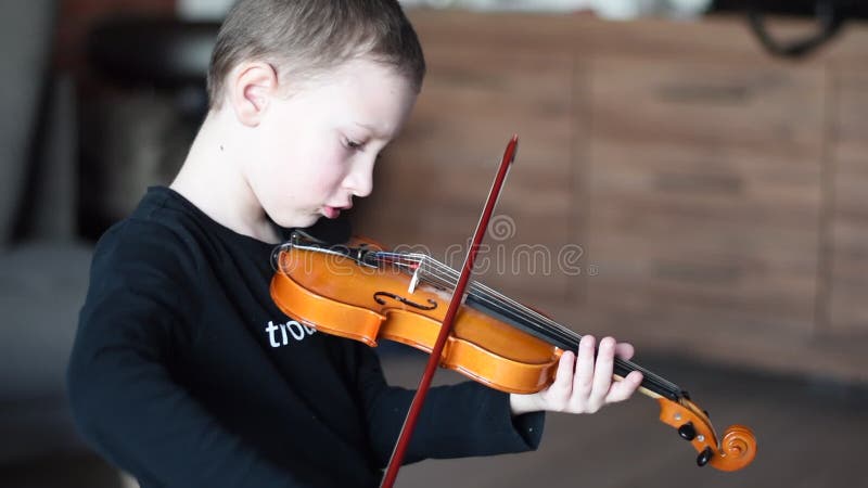 Violín del control de la manija Violín que lleva del niño pequeño Muchacho joven que toca el violín, jugador talentoso del violín almacen de video