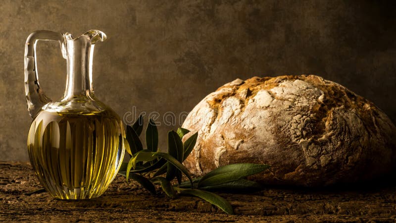 Virgin olive oil in vintage oil jar and rustic bread