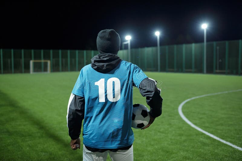 Seção baixa do jogador de futebol profissional que vai chutar a bola de  futebol de pé em um grande campo durante o jogo