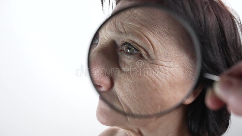 Visage d'une vieille femme sous une loupe banque de vidéos