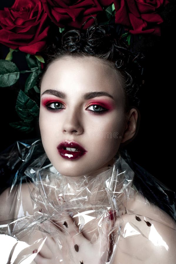 Visage de femme de mannequin de beauté Portrait avec des fleurs de rose de rouge Lèvres et clous rouges Belle femme de brune avec photographie stock libre de droits Visage de femme de mannequin de beauté Portrait avec des fleurs de rose de rouge Lèvres et clous rouges Belle femme de brune avec photographie stock libre de droits