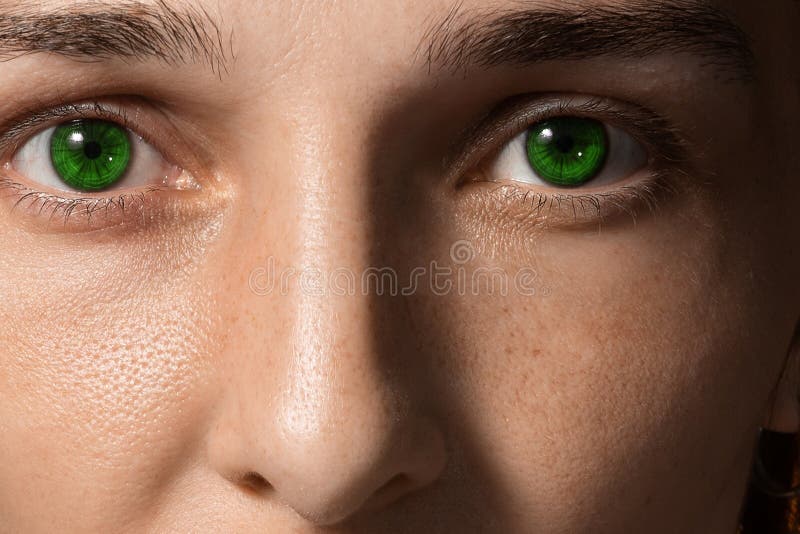 Visage de gros plan d'une fille avec les lentilles et les tâches de rousseur vertes photo stock