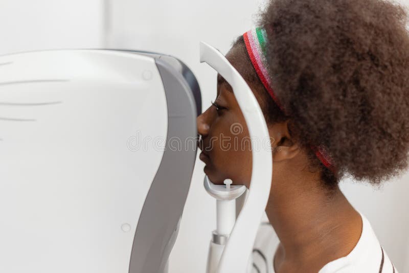 Visage de gros plan jeune femme afro-américaine examen de la vue équipement machine moderne en clinique. photographie stock