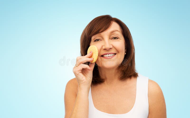 Visage de nettoyage de femme avec s'exfolier l'éponge photographie stock libre de droits Visage de nettoyage de femme avec s'exfolier l'éponge photographie stock libre de droits