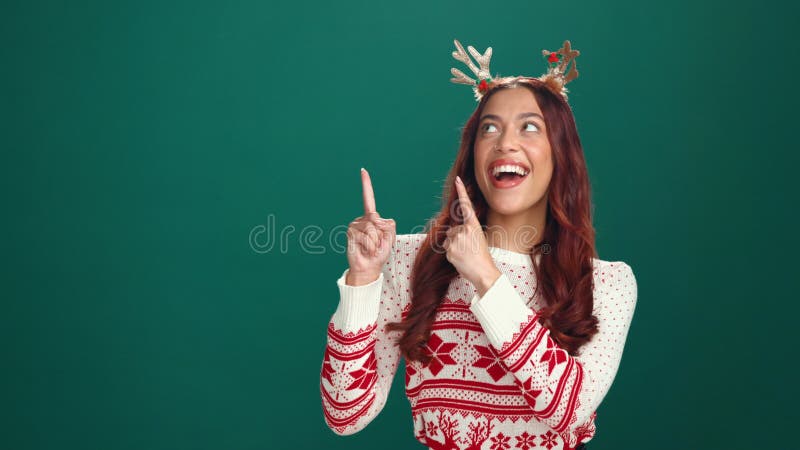 Visage de Noël et femme en studio pointant et annonce sur fond vert. Portrait heureux personne et modèle banque de vidéos
