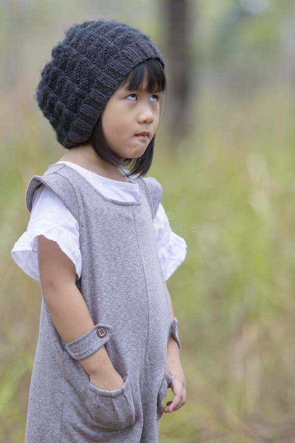 Visage drôle de fille asiatique se tenant sur le champ avec le backg vert de tache floue images libres de droits Visage drôle de fille asiatique se tenant sur le champ avec le backg vert de tache floue images libres de droits
