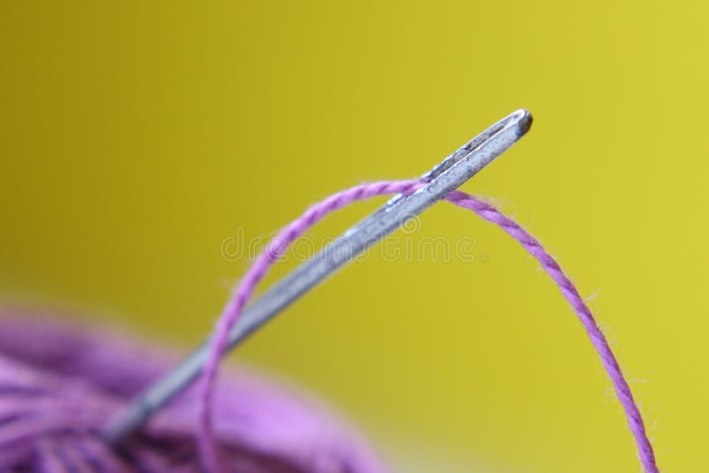 Purple needle and thread on a yellow background. Purple needle and thread on a yellow background