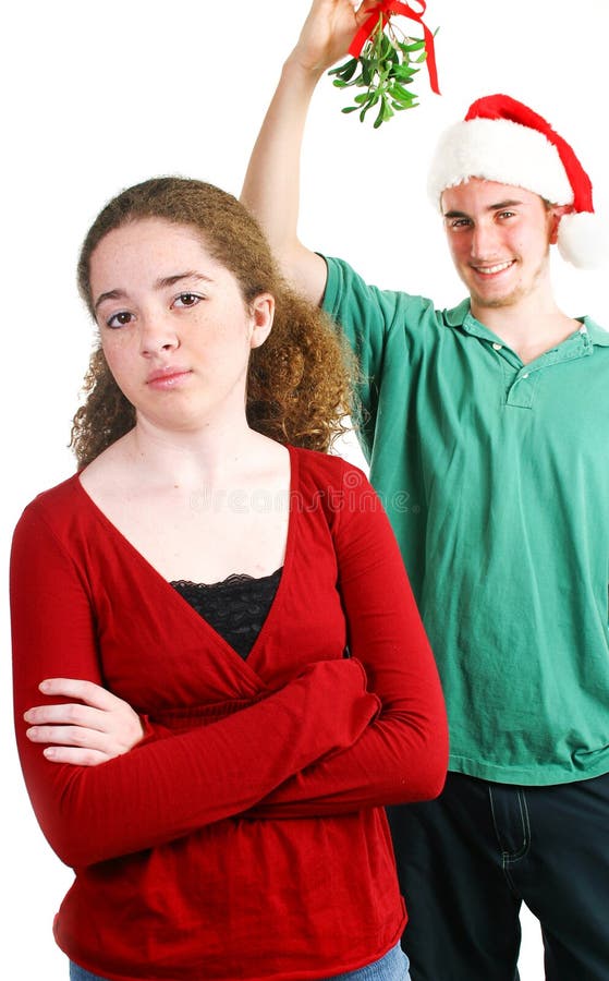 Hopeful teen boy standing under the mistletoe. The girl is not interested in him. Hopeful teen boy standing under the mistletoe. The girl is not interested in him.