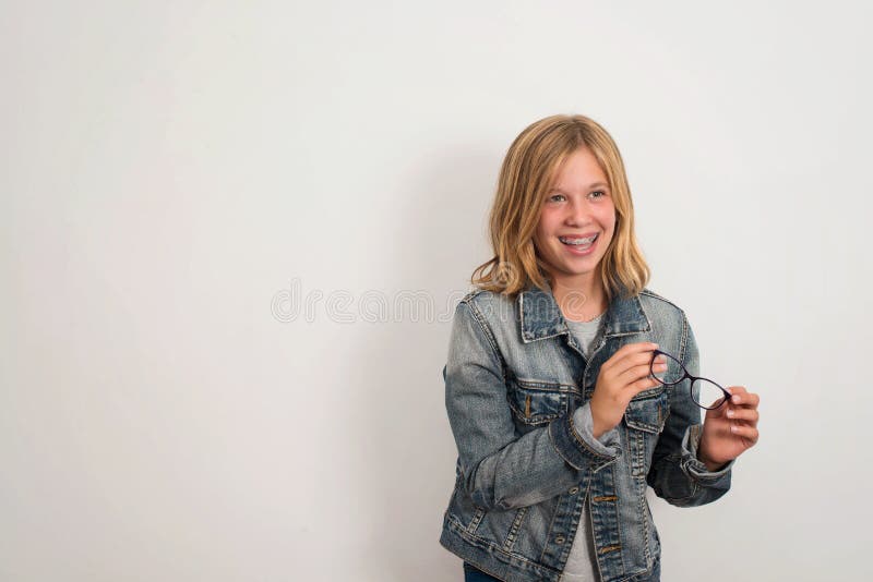 Vision, dental, school, education and people concept. Laughing teen girl in dental braces holding eyeglasses