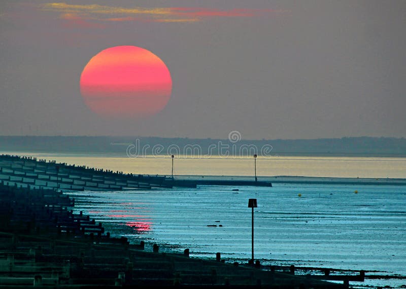 De hermoso otonal el sol configuración través de Costa de sobre el bajo mareas.