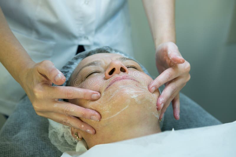 A visit to a beautician. Doctor beautician prepares the patient`s face for the procedure - carboxytherapy. The preparatory stage. Doctor beautician prepares the royalty free stock photography A visit to a beautician. Doctor beautician prepares the patient`s face for the procedure - carboxytherapy. The preparatory stage. Doctor beautician prepares the royalty free stock photography