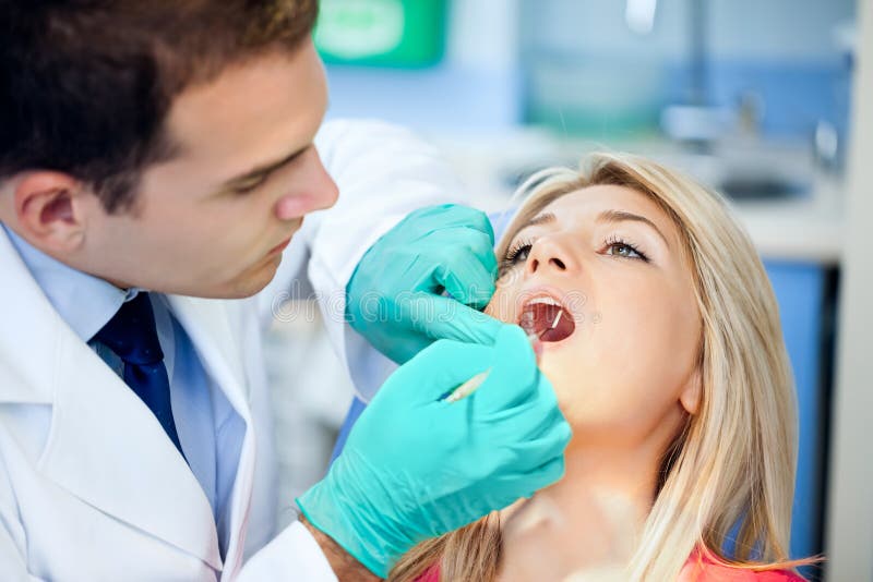 Femmina giovane paziente prende un dentali presenti in dentisti ufficio.