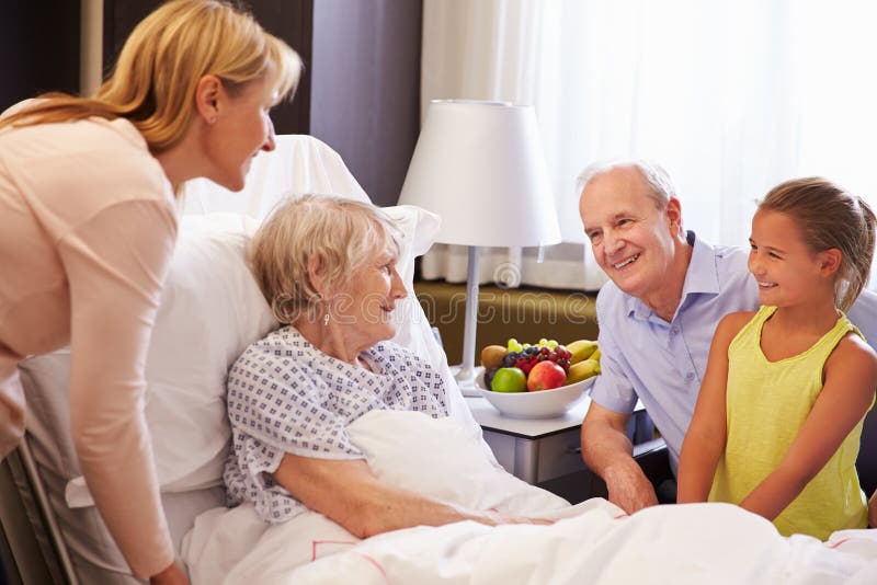 Visita de la familia a la abuela en cama de hospital fotos de archivo libres de regalías