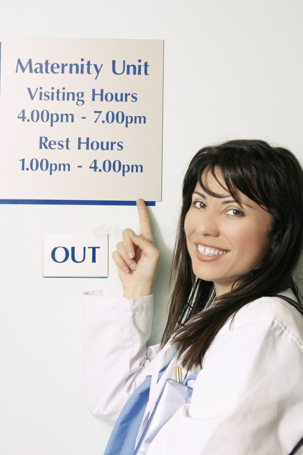 A nurse pointing to the hospital visiting hours sign.