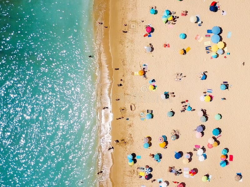 Visión aérea desde el abejón del vuelo de la muchedumbre de la gente que se relaja en la playa