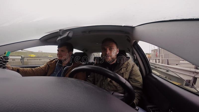 Visión desde la cámara del gopro de la gente joven del grupo que viaja en coche junto Paseo de los amigos a través del embarcader