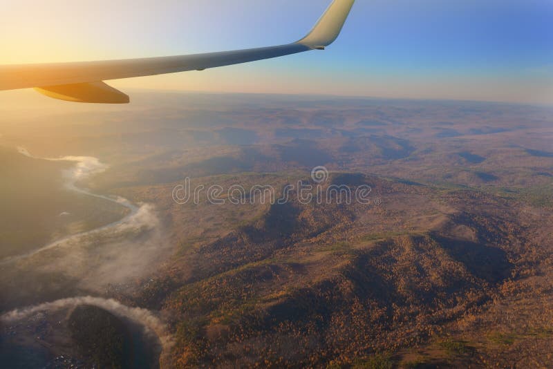 visión desde la ventana del avión al horizonte del lago y del río en las montañas con los bosques en la puesta del sol del día imagen de archivo visión desde la ventana del avión al horizonte del lago y del río en las montañas con los bosques en la puesta del sol del día imagen de archivo
