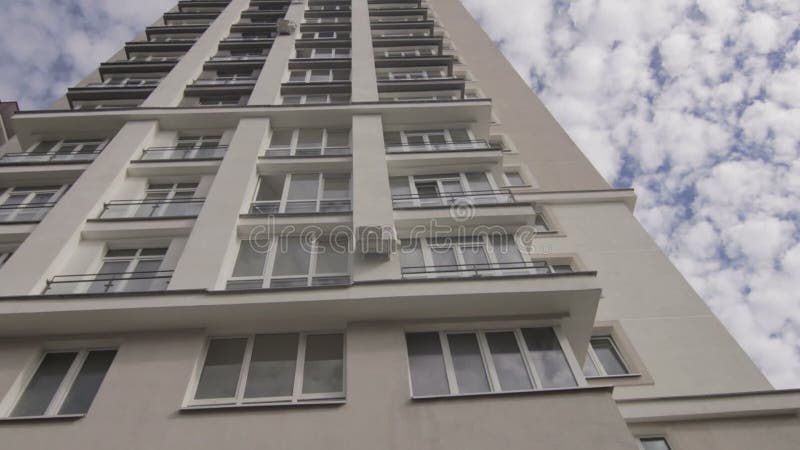 Visión en la nueva casa multi del piso con la reflexión del cielo en las ventanas