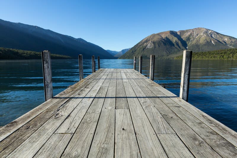Visión sobre el lago hacia las montañas del embarcadero gris imágenes de archivo libres de regalías Visión sobre el lago hacia las montañas del embarcadero gris imágenes de archivo libres de regalías