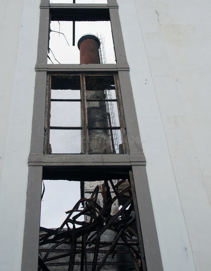 visión a través de la ventana de un edificio abandonado de la fábrica con una chimenea alta visible dentro de las ruinas imágenes de archivo libres de regalías visión a través de la ventana de un edificio abandonado de la fábrica con una chimenea alta visible dentro de las ruinas imágenes de archivo libres de regalías