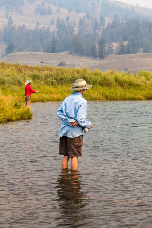 A family fishing in Yellowstone National Park at Slough Creek with fly rods and reels. Smoke is in the air from forest fires in the region. A family fishing in Yellowstone National Park at Slough Creek with fly rods and reels. Smoke is in the air from forest fires in the region.