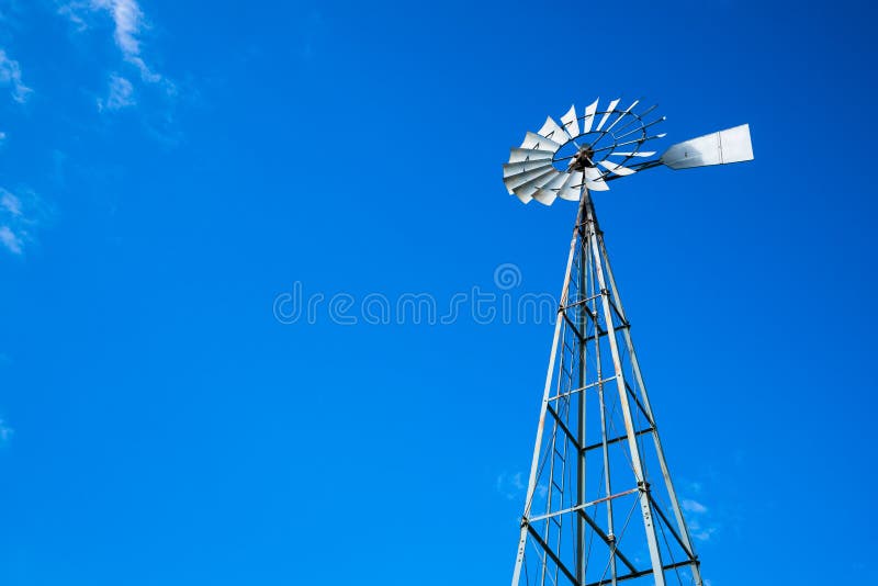 Vista acima no moinho de vento de bombeamento da água alta do metal foto de stock royalty free Vista acima no moinho de vento de bombeamento da água alta do metal foto de stock royalty free
