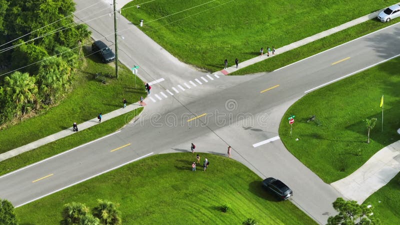 Vista aerea degli scolari che aspettano l'arrivo dell'autobus scolastico. bambini in piedi per strada pronti a essere presi