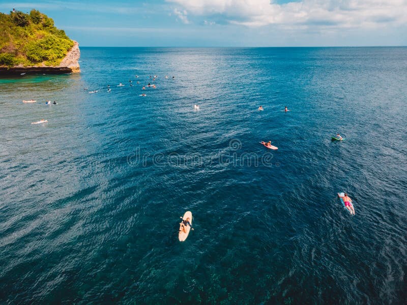 Vista aerea dei surfisti in oceano blu tropicale, Bali fotografia stock libera da diritti Vista aerea dei surfisti in oceano blu tropicale, Bali fotografia stock libera da diritti