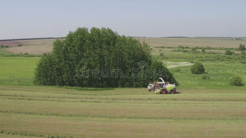 Vista aerea della mietitrebbiatrice che scarica erba in camion mentre raccogliendo nel campo